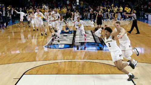 Michigan guard Jordan Poole (2) is chased by teammates after making a 3-point basket at the buzzer to win an NCAA men's college basketball tournament second-round game against Houston on Saturday, March 17, 2018, in Wichita, Kan. Michigan won 64-63. (AP Photo/Charlie Riedel)