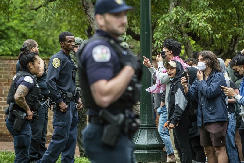 Police and pro-Palestinian demonstrators stand across from one another on the grounds of the University of Virginia, in Charlottesville, Va., where tents are set up, Saturday, May 4, 2024. (Cal Cary/The Daily Progress via AP)