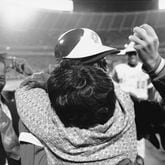Atlanta Braves' Hank Aaron is embraced by his mother, Estella, as his father Herbert, left, nearly loses his hat and Braves pitcher Tommy House holds the ball that Aaron hit to break Babe Ruth's record, April 8, 1974, in Atlanta.  (AP Photo)