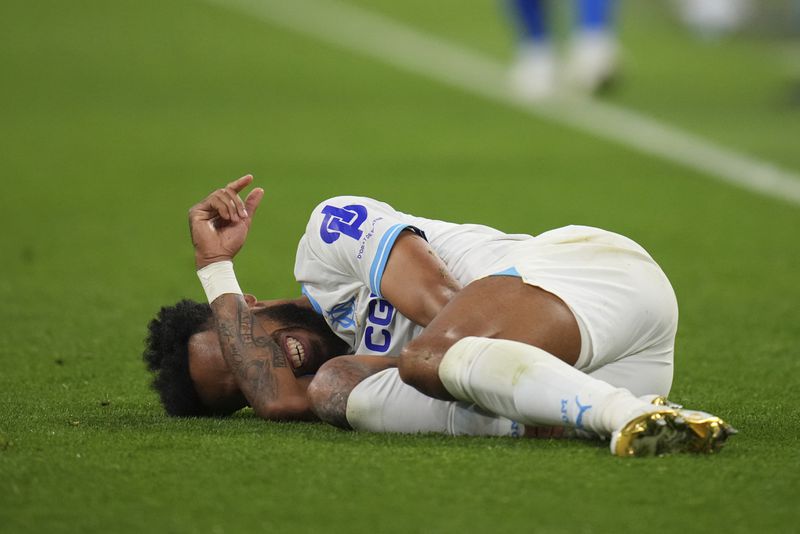 Marseille's Pierre-Emerick Aubameyang grimaces on the ground during a French League One soccer match between Marseille and Lens at the Stade Velodrome stadium in Marseille, France, Sunday, April 28, 2024. (AP Photo/Daniel Cole)