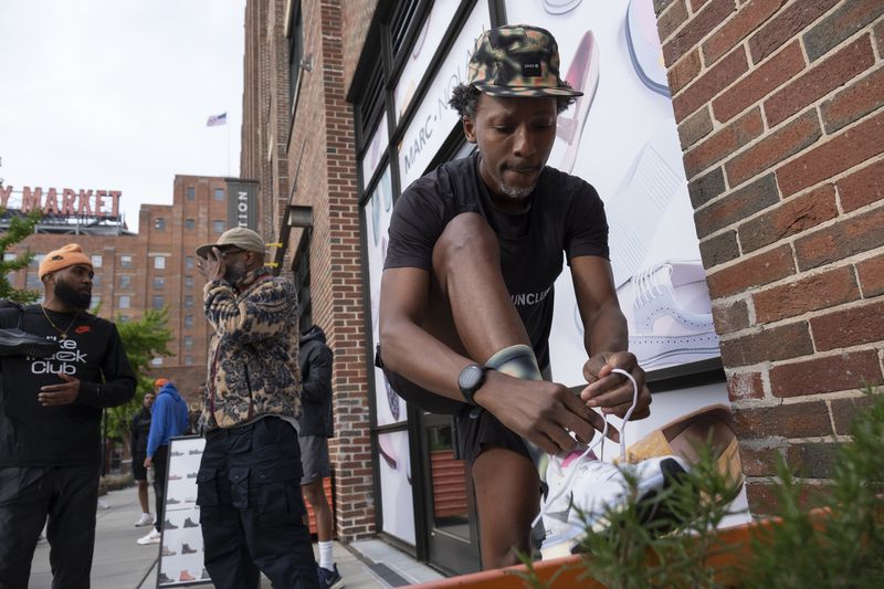 Maurice Garland, a run lead with the Atlanta Run Club, laces up before the start of their Monday night run at Ponce City Market on Monday, March 25, 2024.   (Ben Gray / Ben@BenGray.com)