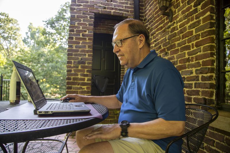 Steve Rushing sits at a table on his front porch that he converted into his office space at his residence in Decatur, Tuesday, June 15, 2021. (Alyssa Pointer / Alyssa.Pointer@ajc.com)