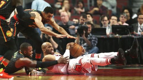 The Chicago Bulls’ Taj Gibson, right, hangs on to a loose ball in front of the Atlanta Hawks’ Thabo Sefolosha (25) and Paul Millsap (4) during the first half at the United Center in Chicago on Wednesday, Jan. 25, 2017. (Nuccio DiNuzzo/Chicago Tribune/TNS)