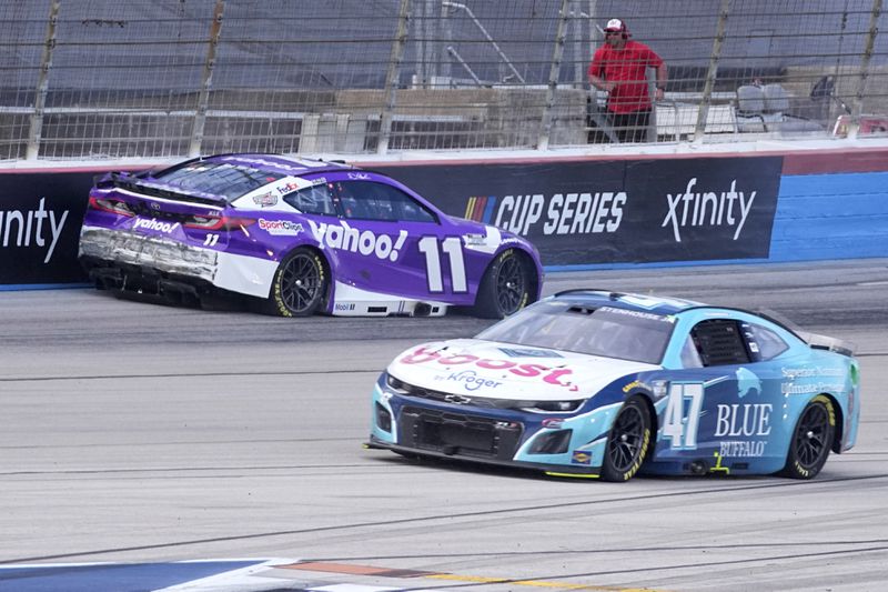 Denny Hamlin (11) crashes coming out of Turn 4 in the final laps as Ricky Stenhouse Jr. (47) races past in a NASCAR Cup Series auto race at Texas Motor Speedway in Fort Worth, Texas, Sunday, April 14, 2024. (AP Photo/Tony Gutierrez)