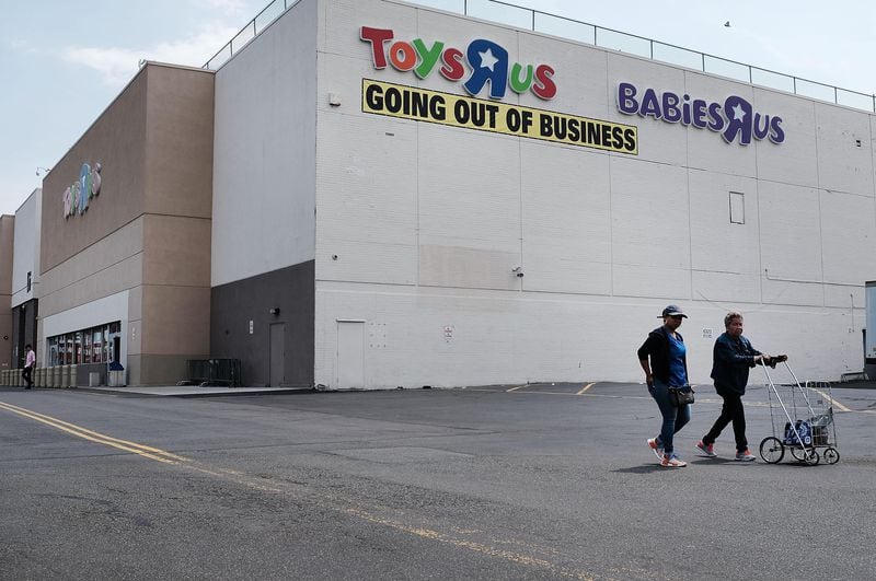 People walk by a Toys R Us store in Brooklyn on June 8, 2018 in New York City. All 735 Toys R Us stores in America are set to close by the end of June leaving  33,000 workers  without a job or  severance pay. Many of the employees losing their jobs have worked for the company for decades. Toys R Us has been owned by the private-equity giant Bain Capital.  (Photo by Spencer Platt/Getty Images)