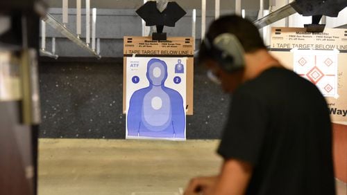 Dylan Jain, of Atlanta, prepares before he shoots a target in the gun range at Stoddard’s Range and Guns on Thursday. HYOSUB SHIN / HSHIN@AJC.COM