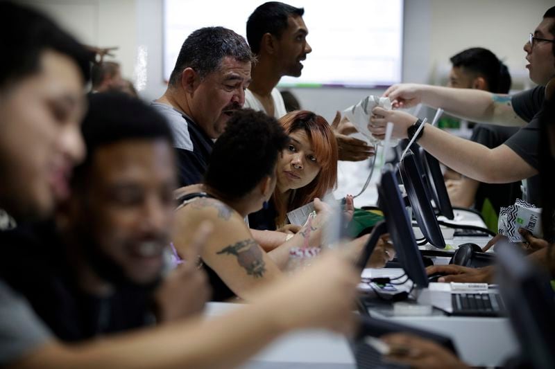 FILE - People buy marijuana products at the Essence cannabis dispensary, Saturday, July 1, 2017, in Las Vegas. Nevada dispensaries were legally allowed to sell recreational marijuana starting at 12:01 a.m., that day. (AP Photo/John Locher, File)