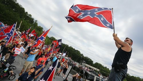 080215 STONE MOUNTAIN: Travis Conklin, Barnesville, waves a flag from the top of his truck durig a pro-Confederate flag rally at Stone Mountain Park on Saturday, August 1, 2015, in Stone Mountain. Curtis Compton / ccompton@ajc.com