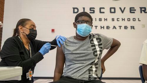 Gwinnett, Newton, Rockdale County Health Department licensed practical nurse Tanya Pleasant gives Central Gwinnett High School freshman Syr Chase Dawson, 14, the Pfizer COVID-19 vaccine during a free vaccination event at Discovery High School in Lawrenceville, Wednesday, August 18, 2021. (Alyssa Pointer/Atlanta Journal Constitution)