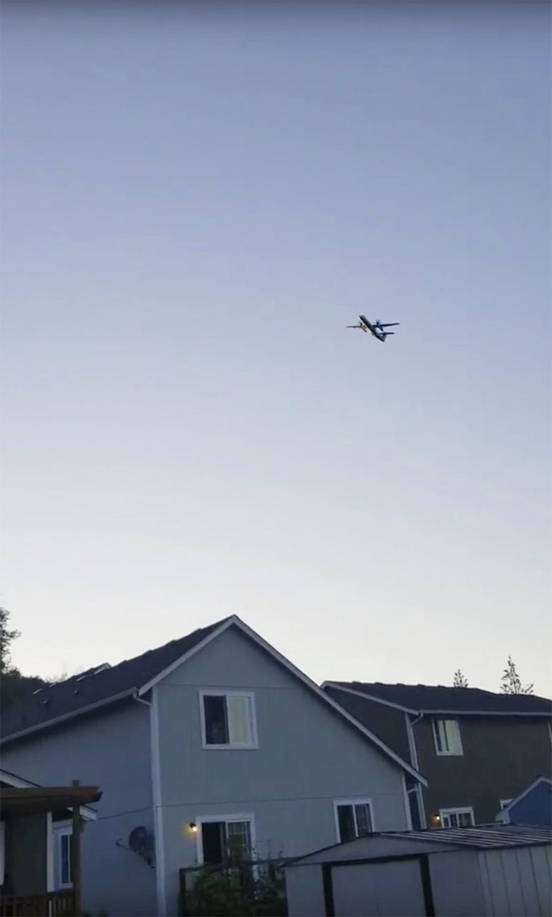 This photo taken from video provided by Courtney Junka shows the stolen Horizon Air turboprop plane flying over Eatonville, Wash., Friday, Aug. 10, 2018. (Courtney Junka via AP)