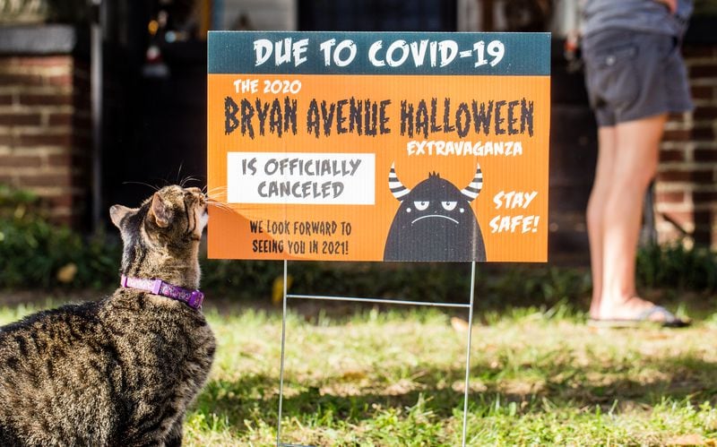The East Point neighborhood around Bryan Avenue replaces Halloween decorations with yard signs announcing the 2020 extravaganza is canceled.  Mr. Tiddles, a mainstay on Bryan Avenue, comes out to show support. Jenni Girtman for The AJC