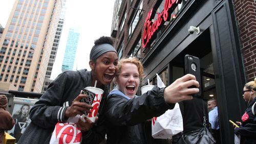 Jaimie Cranford, right, takes a photo with Mariah Reives outside the Chick-fil-A store in New York. Cranford, originally from South Carolina, and Reives, originally from North Carolina, now live in New York. (AP Photo/Tina Fineberg)