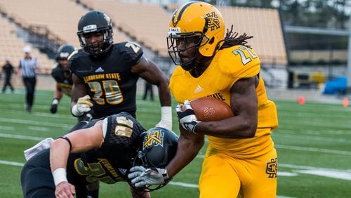 Running back Trey Chivers (22) tries to evade a tackle from Dustin Clabough (30) during the 2017 Kennesaw State spring football game.