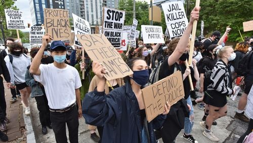 Protesters march around Centennial Olympic Park in downtown Atlanta during a rally on April 14, 2021, in solidarity with Minnesota - Justice for Daunte Wright. (Hyosub Shin / Hyosub.Shin@ajc.com)