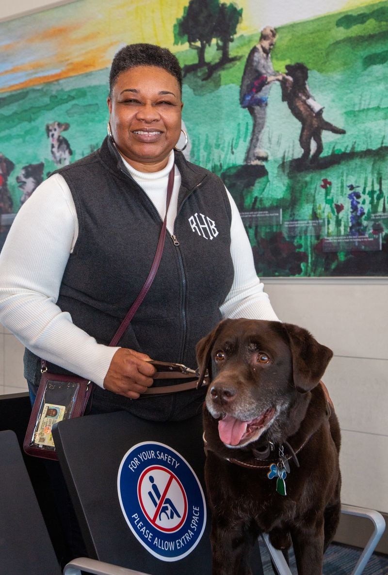 Portrait of Rita Harris & her guide dog Madden who are featured in the mural behind them in Course F at Hartsfield-Jackson International Airport. Harris is a blind women living in Madison who started a nonprofit to help others who are vision impaired. The organization is called Living Life Team.
PHIL SKINNER FOR THE ATLANTA JOURNAL-CONSTITUTION.