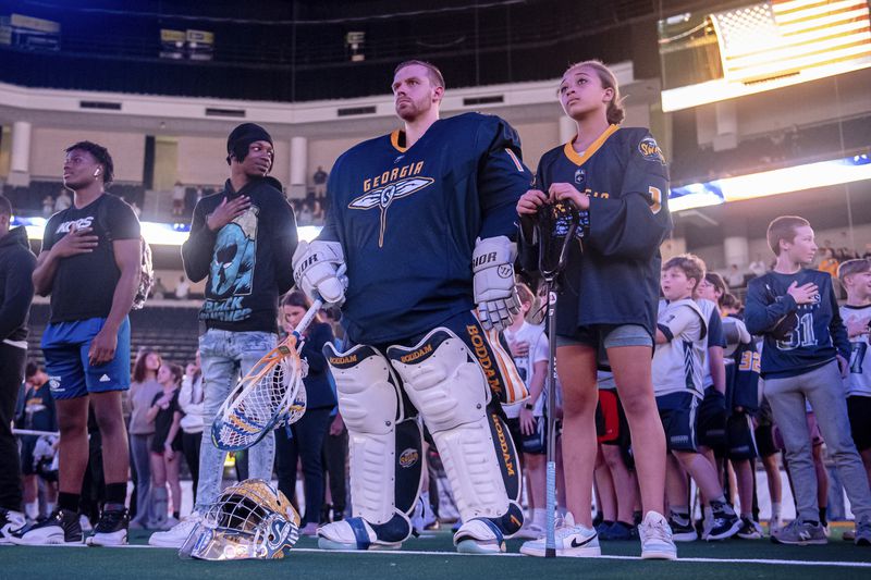 Georgia Swarm goalie Craig Wende and Karaline Apoian stand at attention during the National Anthem at a recent Swarm lacrosse game. Courtesy of Georgia Swarm