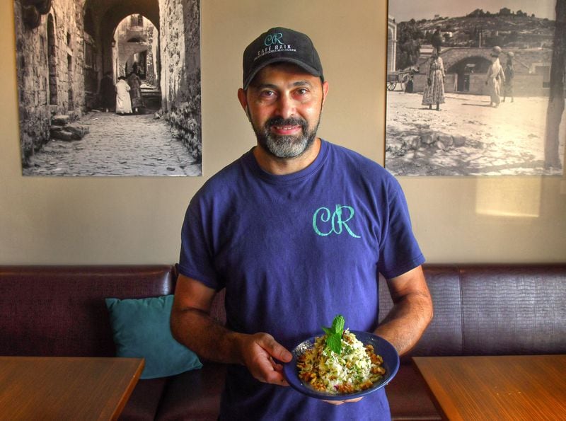 Faik Usman, chef-owner of Cafe Raik in Duluth, displays Chef Faik Usman's Salad of Cabbage, Mint and Walnuts. This recipe is a simple side dish that packs big flavor. Usman is shown at Cafe Raik. (Styling by chef Faik Usman / Chris Hunt for the AJC)