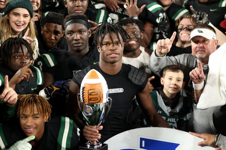 Collins Hill wide receiver Travis Hunter holds the trophy as he and teammates pose for a team photograph after their 24-8 win against Milton in the Class 7A state title football game at Georgia State Center Parc Stadium Saturday, December 11, 2021, Atlanta. JASON GETZ FOR THE ATLANTA JOURNAL-CONSTITUTION
