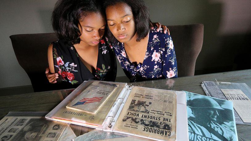 Twin sisters Sharena (left) and Malia Johnson, 17, of Lawrenceville put together a civil rights family heritage project they presented as Girl Scouts in 2011. (The notebook contains the historical documents they presented to supplement their project.) Their family has a place in the Mississippi Civil Rights Museum. CURTIS COMPTON / CCOMPTON@AJC.COM