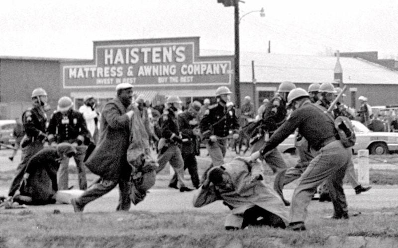 In 1965, John Lewis and Hosea Williams were to lead a group of marchers from Selma to Montgomery to bring attention to voting rights. Instead, the marchers were attacked by state troopers with batons and tear gas as the marchers descended the Edmund Pettus Bridge. Fifty-eight marchers were hospitalized in what became known as "Bloody Sunday." including Lewis (pictured here on the ground), who suffered a fractured skull. Lewis would later say that he expected to die that day. Media coverage of the attack made Lewis a household name, and spurred support for the Voting Rights Act of 1965. As a congressman, Lewis returns to the bridge annually to commemorate the event. (AP file)