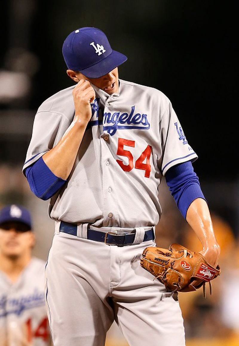 Los Angeles Dodgers relief pitcher Jim Johnson wipes his face after Pittsburgh Pirates' Aramis Ramirez drove in Starling Marte with one of the Pirates' nine runs in the seventh inning of a baseball game, Sunday, Aug. 9, 2015, in Pittsburgh. (AP Photo/Keith Srakocic)