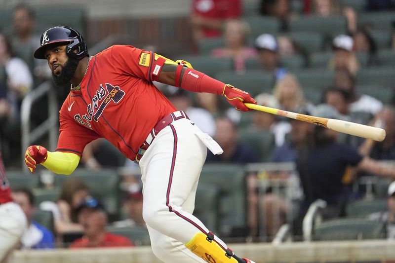 Atlanta Braves designated hitter Marcell Ozuna drives in a run with a base hit off Texas Rangers pitcher Andrew Heaney in the first inning of a basedball game Friday, April 19, 2024, in Atlanta. (AP Photo/John Bazemore)
