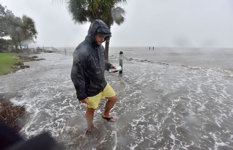 Aric Sparmann of Brunswick comes out to take some photographs near St. Simons Pier as Hurricane Matthew approaches in St. Simons Island on Friday morning, October 7, 2016.