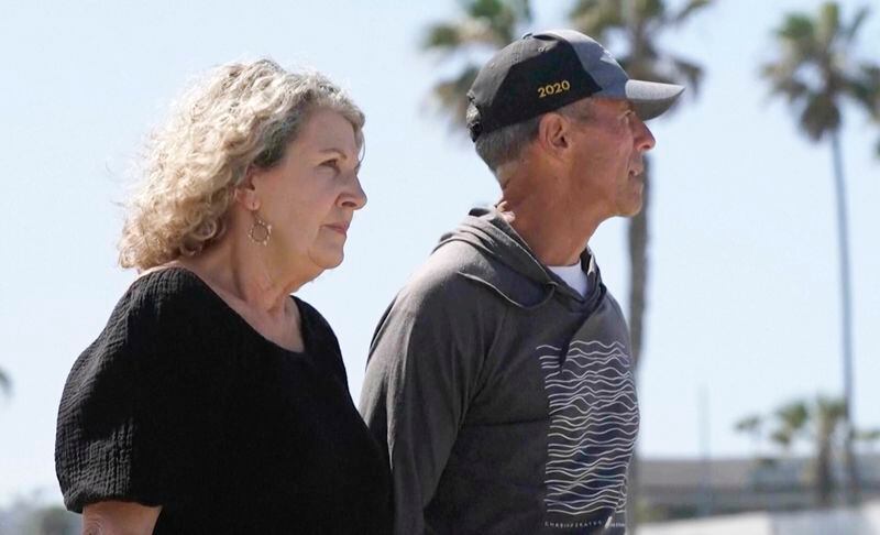 In this image taken from video, Australia's Debra Robinson stands with her husband Martin, following a media conference on the beach in San Diego, Tuesday, May 7, 2024 following the deaths in Mexico of their two sons during a surfing trip. The sons, Callum and Jake, and U.S. friend Jack Carter Rhoad, were allegedly killed by car thieves in Baja California, across the border from San Diego, somewhere around April 28 or 29. (Channel 9/POOL via AP)