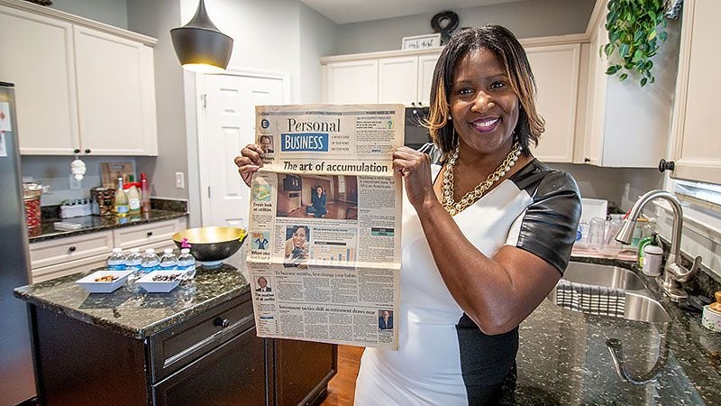 Phyllis Starks holds up the March 20, 1995 copy of the Atlanta Journal-Constitution in her home in Mableton Saturday, January 18, 2020. Starks appeared on in the business section talking about her personal finance. Starks had realized that she needed to change her long-term financial strategy because she spent more money on shoes than she invested.