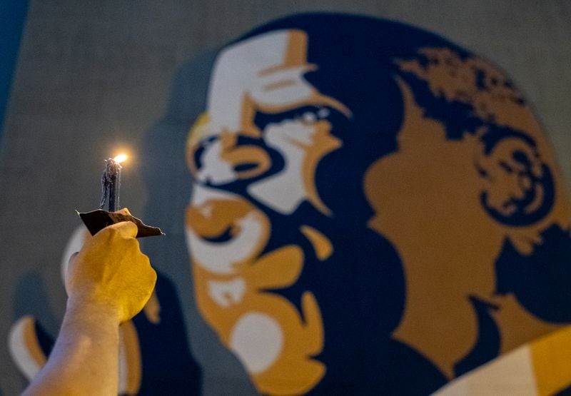 200719-Atlanta-A man holds his candle high in front of the mural of John Lewis during a celebration of his life Sunday evening July 19, 2020. Ben Gray for the Atlanta Journal-Constitution