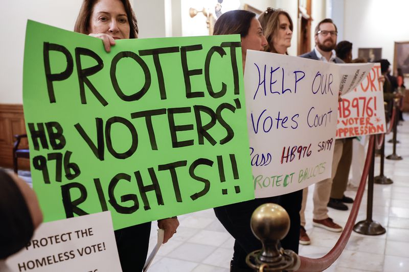 Activists hold signs in support of House Bill 976 at the Georgia State Capitol on Thursday.