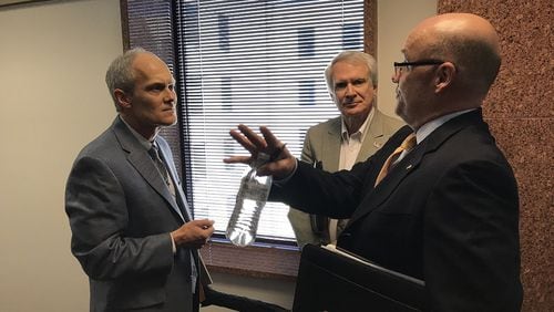 Decatur City Attorney Bryan Downs, left, in a heated exchange with Immigration Enforcement Review Board member Phil Kent and board chairman Shawn Hanley, right. JEREMY REDMON/jredmon@ajc.com
