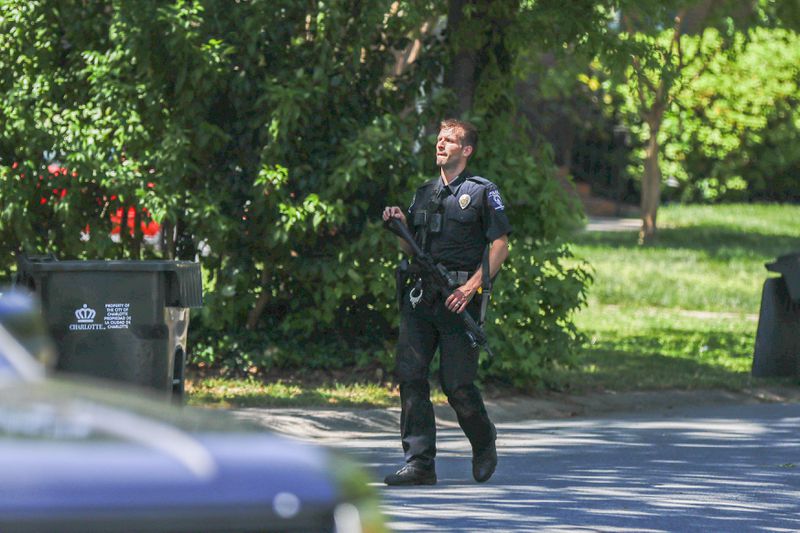A Charlotte Mecklenburg police officer walks in the neighborhood where several officers on a task force trying to serve a warrant were shot in Charlotte, N.C., Monday, April 29, 2024. (AP Photo/Nell Redmond)