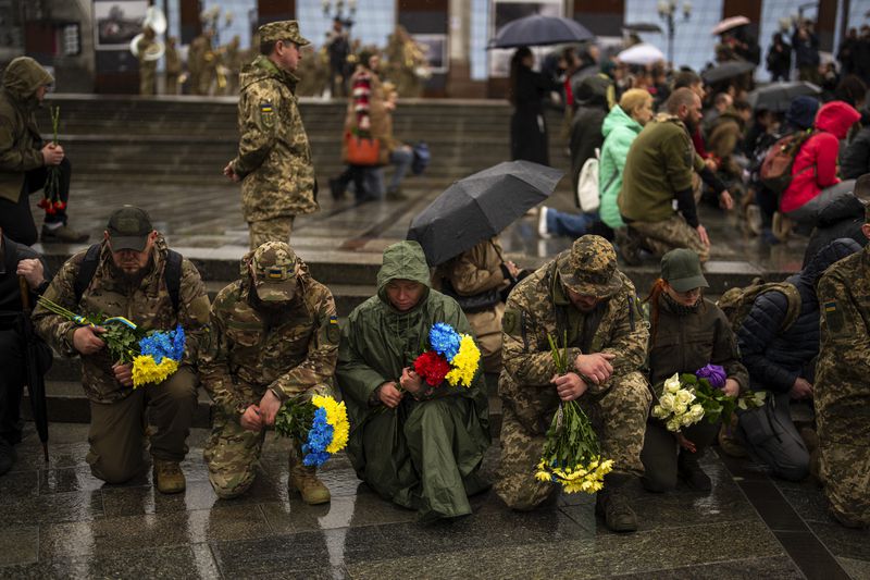 Family, friends and army comrades gather to pay respect to Ukrainian army paramedic Nazarii Lavrovskyi, 31, killed in the war, during his funeral ceremony at Independence square in Kyiv, Wednesday, April 24, 2024. Lavrovskyi, who served in the 244th battalion of the 112th Separate Territorial Defense Brigade, was killed April 18 while helping to evacuate wounded troops from the frontline in the Kharkiv area of eastern Ukraine. (AP Photo/Francisco Seco)