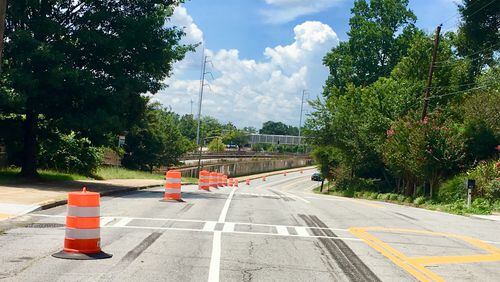 Decatur’s West Howard Avenue looking west towards the East Lake MARTA station. This stretch has mostly been trimmed from four to two lanes, with some dedicated turn lanes. The orange and white cylinders mark the site of future landscaping, with the PATH Stone Mountain Trail to the left. Bill Banks for the AJC