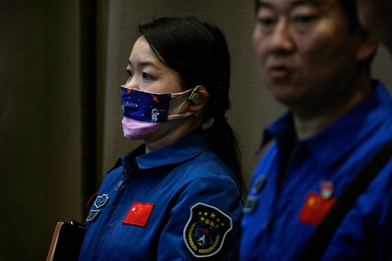 A staff member wearing a face mask depicting a Chinese astronaut in a space as they attend a press conference for the upcoming Shenzhou-18 mission at the Jiuquan Satellite Launch Center in northwest China, Wednesday, April 24, 2024. (AP Photo/Andy Wong)