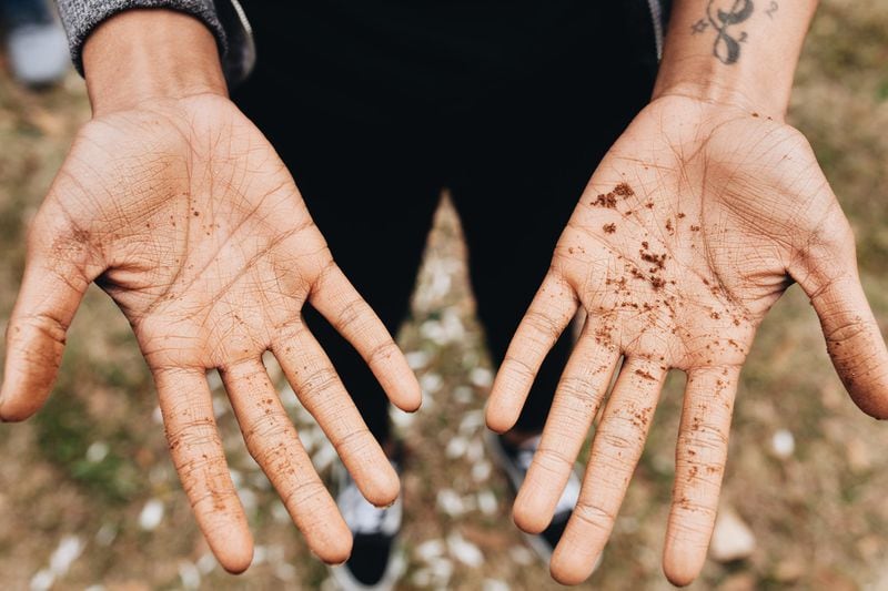 The hands of Kera Lamotte are shown after soil collection for Floyd Carmichael, who was reportedly shot to death by a mob without a trial after a white woman reported being assaulted, according to the Equal Justice Initiative. CONTRIBUTED BY REY GRANGER / FULTON COUNTY REMEMBRANCE COALITION