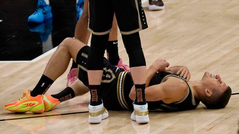 Atlanta Hawks guard Bogdan Bogdanovic (13) lies on the court after an injury during the first half of Game 6 of an NBA basketball Eastern Conference semifinal series against the Philadelphia 76ers, Friday, June 18, 2021, in Atlanta. Bogdanovic stayed in the game. (AP Photo/John Bazemore)