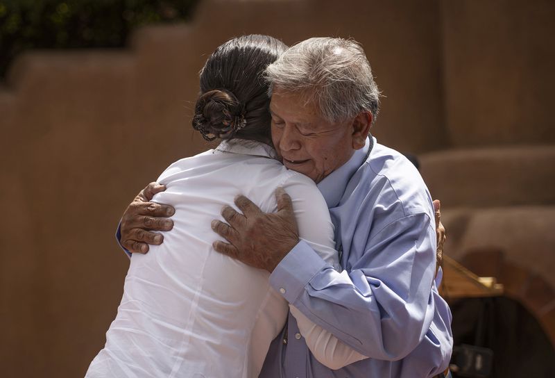 Interior Secretary Deb Haaland hugs Gov. Myron Armijo of Santa Ana Pueblo before signing Public Land Order 7940, which protects more than 4,200 acres of Bureau of Land Management-managed public lands that is sacred to Tribes in the Placitas area, during a community event at El Zócalo Plaza in Bernalillo, N.M., Thursday, April 18, 2024. For the next 50 years, the lands will be closed to new mining claims, mineral sales, and oil and gas leases. (Chancey Bush/The Albuquerque Journal via AP)