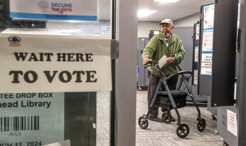 Lee Roy Cottingham gets ready to cast his ballot at the Buckhead Library on Monday, the first day of early voting for Georgia's March 12 presidential primary. (John Spink / John.Spink@ajc.com)


