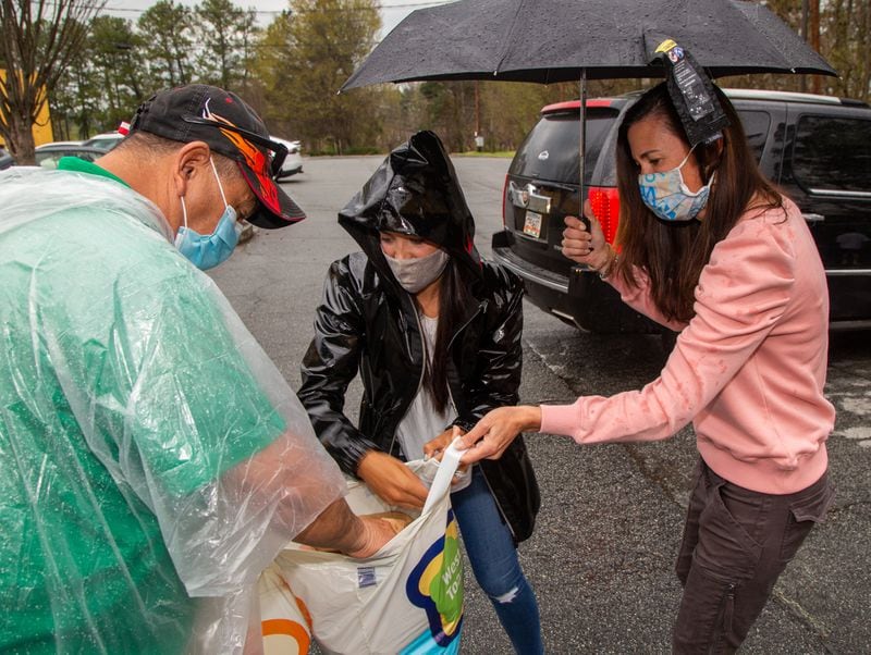 Pedro Barahona (from left) gets Easter meals from Compassion Kitchen Project co-founders Isabel Rice and Lisa Blanco at The Mission church in Atlanta on Thursday March 25th, 2021. PHIL SKINNER FOR THE ATLANTA JOURNAL-CONSTITUTION.