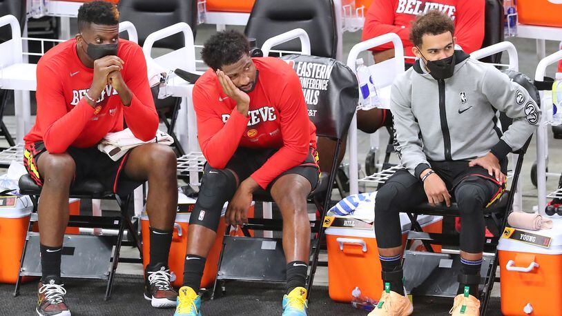Clint Capela (from left), Solomon Hill and Trae Young watch from the bench in the final minutes of a 125-91 loss to the Milwaukee Bucks during game 2 in the NBA Eastern Conference Finals to even the series 1-1 on Friday, June 25, 2021, in Milwaukee.