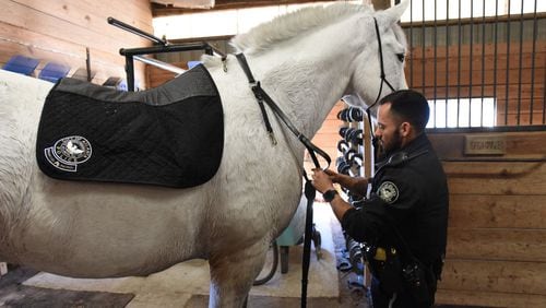 Officer Juan Restrepo prepares his patrol horse Hercules at the Atlanta Police Department's mounted patrol unit stables.