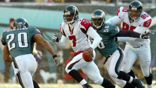 Falcons quarterback Mike Vick scrambles upfield for a long run under pursuit by Eagles Brian Dawkins (20) and Derrick Burgess (56) while Falcons' end Eric Beverly (80) makes the block in the backfield in the first quarter of the NFC Championship game at Lincoln Financial Field on Sunday, January 23, 2005. (CURTIS COMPTON/AJC staff)