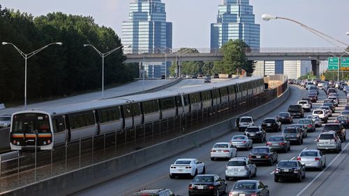 A MARTA train makes its way North past Ga. 400 traffic. Fulton County is considering expanded transit services. BEN GRAY / AJC FILE PHOTO