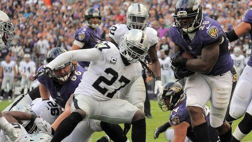 Baltimore Ravens running back Terrance West (28) runs into the end zone past Oakland Raiders free safety Reggie Nelson (27) during the fourth quarter on Sunday, Oct. 2, 2016 in Baltimore, Md. (Karl Merton Ferron/Baltimore Sun/TNS)