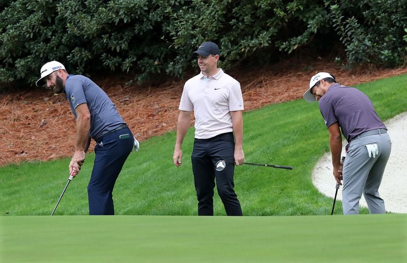 Dustin Johnson (left), Rory McIIroy (middle), and Xander Schauffele practice their putting at the 13th green.   “Curtis Compton / Curtis.Compton@ajc.com”