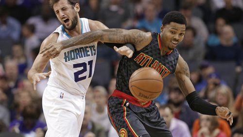Charlotte Hornets' Marco Belinelli (21) collides with Atlanta Hawks' Kent Bazemore (24) as they chase a loose ball in the first half of an NBA basketball game in Charlotte, N.C., Friday, Nov. 18, 2016. (AP Photo/Chuck Burton)