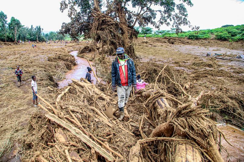 People walk through an area swept away after a dam burst in Kamuchiri Village Mai Mahiu, Nakuru County, Kenya, Monday, April. 29, 2024. Kenya's Interior Ministry says at least 45 people have died and dozens are missing after a dam collapsed following heavy rains. (AP Photo/Patrick Ngugi)