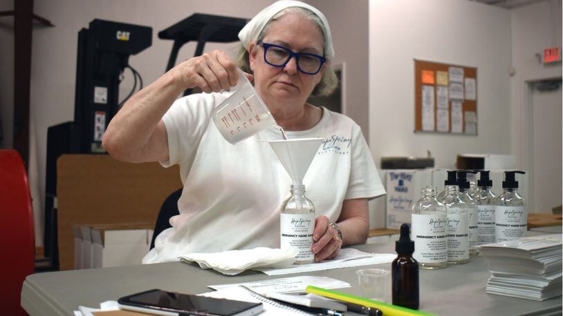 Betsey Dahlberg, co-founder of Hope Springs Distillery, fills a bottle with hand sanitizer. Photo credit: Hope Springs Distillery